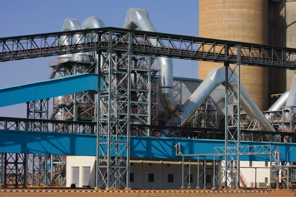 A detailed view of a large industrial factory facility with steel structures and towering pipes.