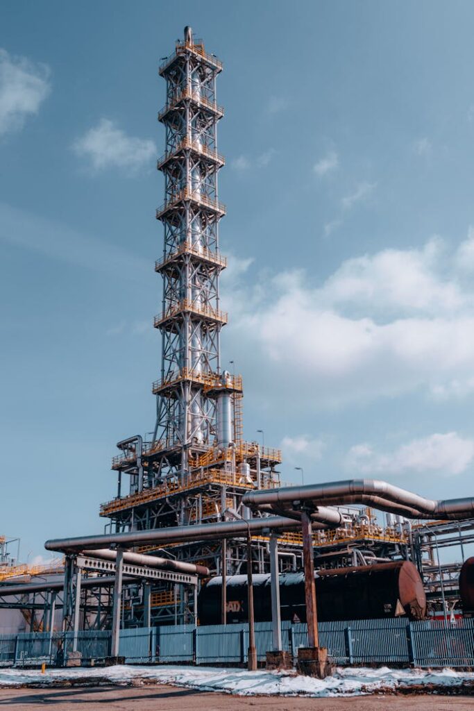 Vertical shot of an oil refinery tower in Trzebinia, Poland against a clear sky.